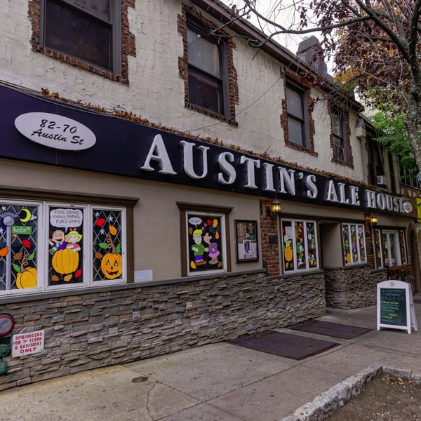Austin's Ale House exterior with Halloween window decorations, stone facade, and a sidewalk sign.