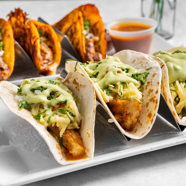 Austin's Ale House tacos: three fish tacos with green sauce and three birria tacos with dipping sauce.