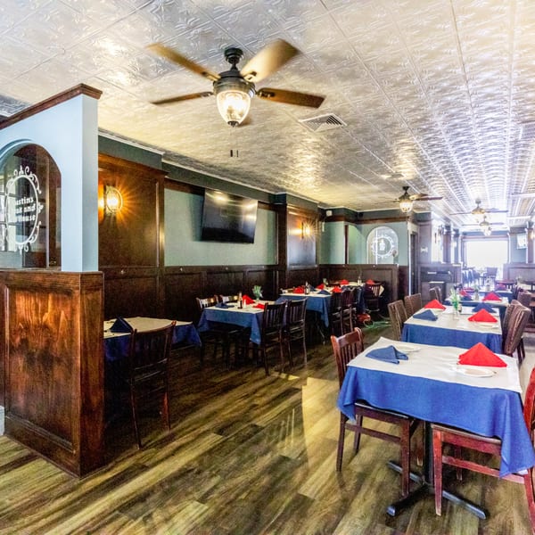 Interior of Austin's Ale House dining room with set tables, wood paneling, and ceiling fans.