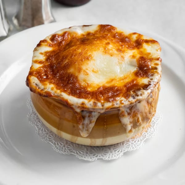 A crock of Austin's Ale House French onion soup, topped with melted, bubbly, golden-brown cheese.