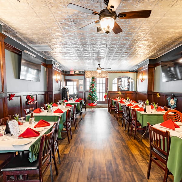 Austin's Ale House dining room set for Christmas, with tables, chairs, and a decorated tree.