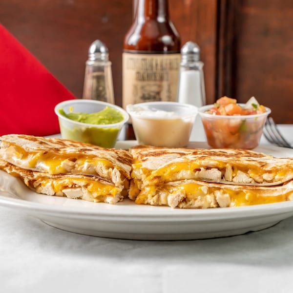 Chicken quesadillas with melted cheese, served with guacamole, sour cream, and salsa at Austin's Ale House.