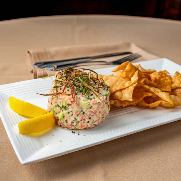 Austin's Ale House salmon tartare with avocado, chives, crispy onions, lemon wedges, and wonton chips.